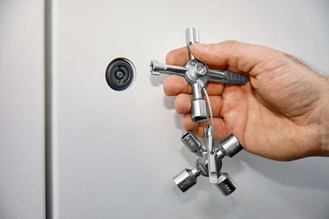 Hand holding TwinKey Multifunctional Spanner Kit With Magnetic Eight Arm Two By Four Way Spider Keys for control cabinets.