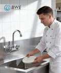 Chef using Commercial Wall Mount Kitchen Faucet With Two Handles 4 Inch Center Set Swivel Gooseneck Spout Chrome Finish in kitchen