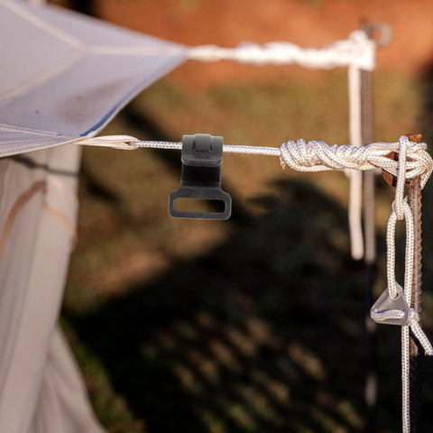 Close-up of a large plastic camping tent hook attached to a rope, highlighting its sturdy design for hanging outdoor gear.