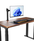 Single Computer Monitor Stand With Cable Management And Height Adjustable VESA Desk Arm Mount For 13 To 30 Inch Screens, Fully Adjustable Tilt And 360 Degree Rotation, Steel And Black on a wooden desk with a monitor.
