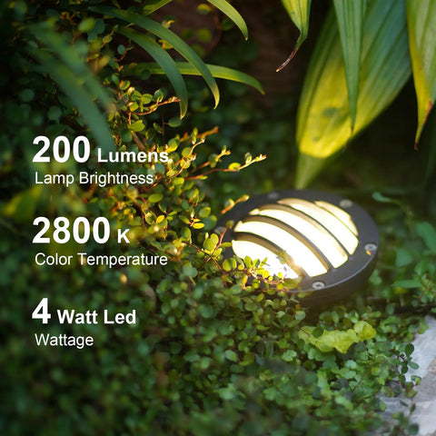 Close-up of installed Low Voltage Landscape Well Lights 4 Pack 4W LED path light emitting 200 lumens, 2800K warm white in garden foliage