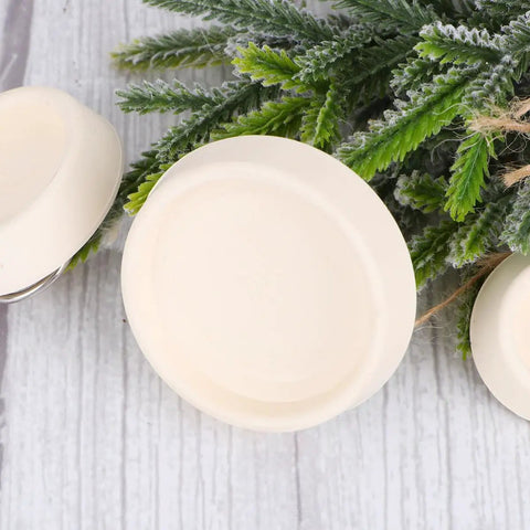 4pcs Rubber Sink Stopper Plug with Hanging Ring for Bathtub Drains placed on greenery, showing smooth, round design and light color.
