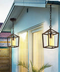 Outdoor Porch Pendant Light With Glass Shade, Vintage Metal Cage Lantern by house exterior at dusk