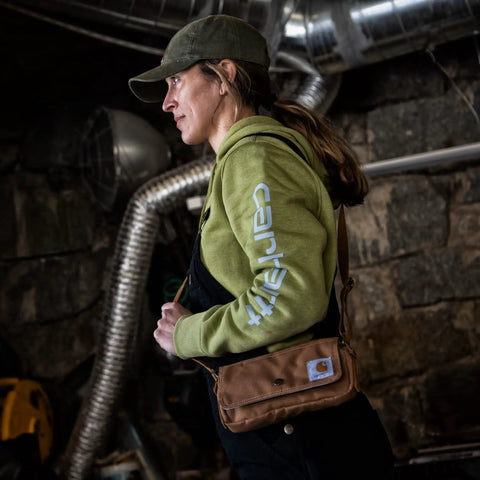 Person wearing Legacy Womens Essentials Convertible Crossbody Bag And Waist Pouch in rustic setting.