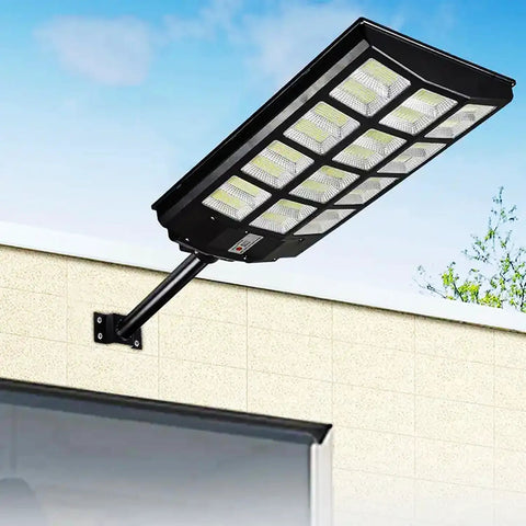 JUDYSSY Solar Street Lights Outdoor Remote Control mounted on wall, showing sleek design and bright LEDs.
