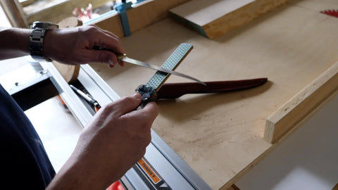 Person using Dia Fold Handy Portable Pocket Diamond Sharpener Double Sided With Extra Fine And Fine Grits on a knife