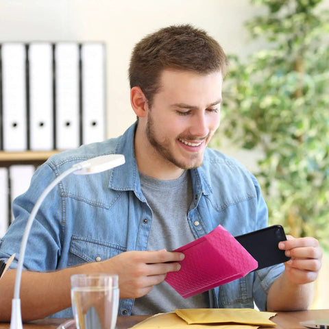 Man placing phone in Hot Pink Bubble Mailers 4x8 Inch Pack Of 50 Waterproof Padded Envelopes at office desk