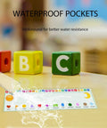 Waterproof 36 Pack Transparent Self-Adhesive Nameplate Pockets For Desks on table with alphabet blocks, 18.9 x 4.7 inches, 7 mil thick.