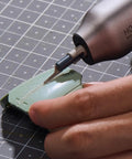 Hardcore Eight Piece Saw Blade Set Fits Neosander Sander To Create A Mini Reciprocating Saw Setup With Heavy Duty Anti Binding Jigsaw Blades Built For Smooth Straight And Curved Cuts On Wood Plastic Or Resin Without Breaking A Sweat, detailing a green plastic piece with a Neosander tool.