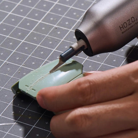 Hardcore Eight Piece Saw Blade Set Fits Neosander Sander To Create A Mini Reciprocating Saw Setup With Heavy Duty Anti Binding Jigsaw Blades Built For Smooth Straight And Curved Cuts On Wood Plastic Or Resin Without Breaking A Sweat, detailing a green plastic piece with a Neosander tool.