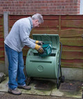 Person using Back Porch Compost Tumbler For Small Yards And Urban Spaces With Odor Control And Fully Enclosed Design That Keeps Animals Out