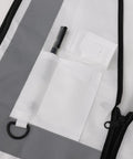 Close-up of white high visibility safety vest with five handy pockets and zipper, highlighting storage options.