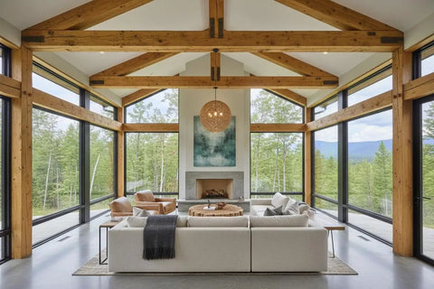 Spacious living room with wooden beams, large windows, warm oak accents, and a cozy sectional sofa.