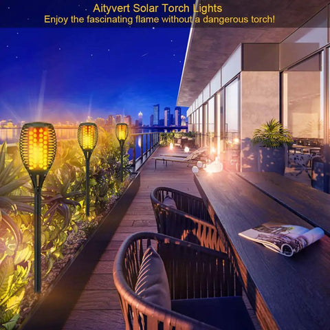 4 Pack 43 Inch Solar Torch Lights With 96 LEDs, Outdoor Waterproof Landscape Pathway Lighting, Realistic Flickering Flame Effect For Patio Vibes, Dusk To Dawn Auto On Off, Yard Garden Decor installed on modern patio at sunset