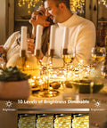 Couple enjoying dinner with 4 Pack 100 LED Fairy Lights Battery Operated With Remote 33Ft Waterproof Twinkle String Lights