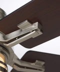 Close-up of 54-inch indoor ceiling fan with reversible wood blades in brushed steel fixture