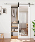 Space-Saving Barn Door With White Primed Glass Mirror Panel And Solid Wood Frame, Dual-Purpose Full-Length Dressing Mirror With Half-Frosted Glass For Privacy And Light Diffusion, Installation Hardware Included, 28 By 80 Inches installed in a bedroom closet.