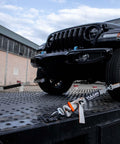 Complete Axle Strap Tie Down Kit With Snap Hook Ratchet Straps Silver Series Webbing in use securing a vehicle on a trailer