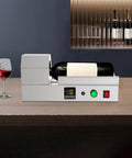Plug And Play Electric Pvc Bottle Cap Heat Shrinker 110V Tabletop Sealer in stainless steel with wine bottle and glass.