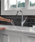 Ophelia Chrome Kitchen Faucet With Pull Down Sprayer in use at modern sink, high arc design with ShieldSpray technology reducing splatter
