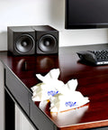 Audiowipes towelettes wrappers with blue logo on dark wood desk beside a computer keyboard