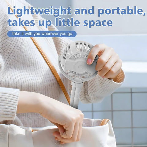Person placing Mini Portable Baby Stroller Fan On The Go, 3 Speed Personal Handheld Cooling, into a bag.