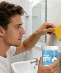 Man applying hydrophobic wall putty for quick crack repair and easy go to application in bathroom, durable drywall compound.
