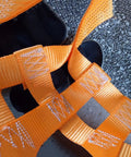 Heavy Duty Polyester Lifting Net For Brick And Cement Hauling, showing vibrant orange straps on a surface.