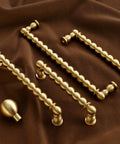 Brushed Brass Ball Drawer Knobs and Cabinet Pulls Set for Kitchen Cabinets and Furniture Hardware on brown fabric
