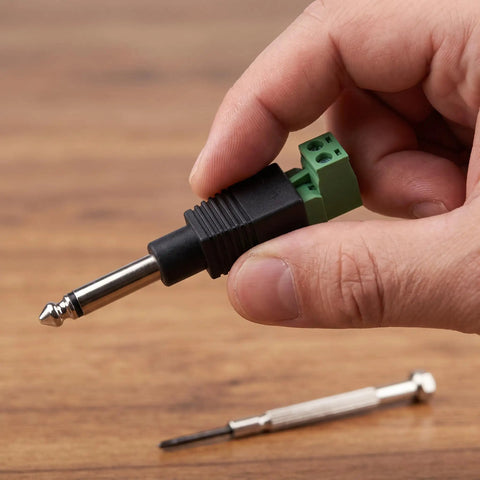 Straight Up 1/4 Inch Jack Mono Male Plugs For Electric Guitar And Stage Mixer Cables 6.35mm in hand with green connector.