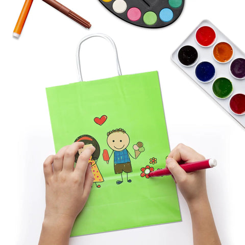 Child decorating a green gift bag from the 32 Piece Gift Bags Set With 32 Tissues Eight Color Rainbow Party Favors With Handles For Wedding Birthday Parties And Gifts Ideal For Gift Wrapping Party Decor Event Giveaways School And Baby Showers.