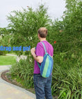 Person carrying a blue green striped pouch containing Extra Long And Wide Double Hammock For Travel Camping Backyard Porch Or Indoor Use