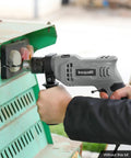 Person using Corded Hammer Drill With 3000 RPM And 4.5 Amp Motor, Half Inch Keyed Metal Chuck, in workshop setting