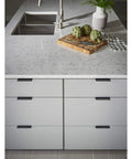 Modern kitchen with Mercer Collection Europa Tab Pull 3 Inch Length Brushed Satin Nickel Finish on cabinet drawers under marble counter