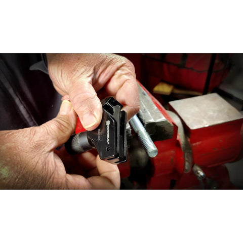 Powerbuilt universal thread repair tool, black, for SAE 5/32–3/4 in and metric 4–19 mm, shown in hand near a vise.