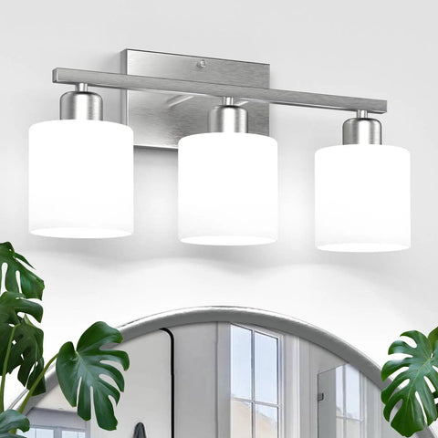 Three Bulb Over Mirror Bathroom Vanity Light In Brushed Nickel Finish Rustproof Wall Sconce mounted above a mirror with frosted glass shades.