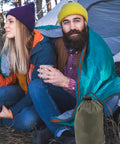 Couple using Emergency Blanket Set With Green Aluminum Thermal Rescue Blanket And A Carry Bag For Camping And Hiking Survival Warmth