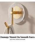 Kick Clutter To The Curb With This Slick Space Saving Wall Hook on smooth surface holding a towel, featuring striped acrylic and gold metal.