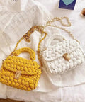 Yellow and white woven handbags with gold twist lock clasps on white fabric