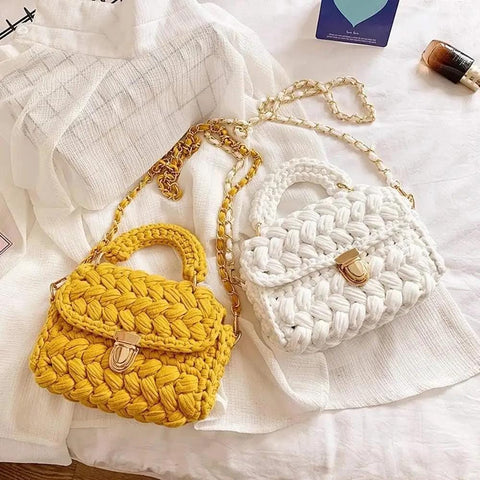 Yellow and white woven handbags with gold twist lock clasps on white fabric