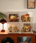 Four Charming Bistro Style Miniature House Kits With LED displayed on a shelf, each with unique cozy cafe vibes.