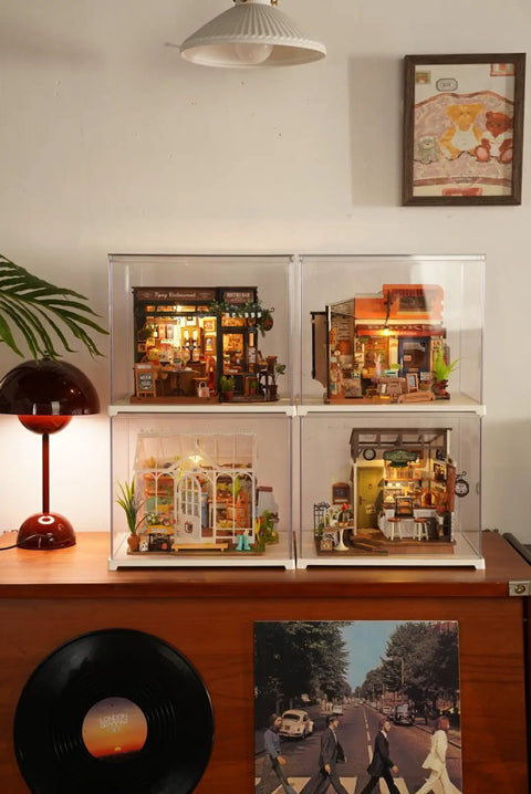 Four Charming Bistro Style Miniature House Kits With LED displayed on a shelf, each with unique cozy cafe vibes.
