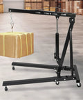 Heavy Duty 2 Ton Engine Hoist And Folding Hydraulic Shop Rig, 4400 Lbs Carbon Steel Garage Lift holding a cardboard package.