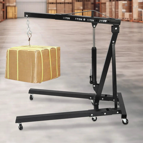 Heavy Duty 2 Ton Engine Hoist And Folding Hydraulic Shop Rig, 4400 Lbs Carbon Steel Garage Lift holding a cardboard package.