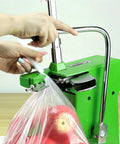 Heavy Duty Desktop Plastic Bag Sealing Machine Ties Bags Fast With Adjustable Pressure And Built-in Cutter Includes 2000 U-Shaped Clips Perfect For Fruit Shops And Small Biz sealing a plastic bag with apples.
