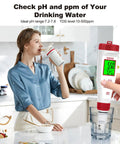 Woman using 4 In 1 Digital Water Tester with Backlit Display for pH TDS EC and Temperature in kitchen, testing water quality.