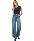 Head Turner High Rise Wide Leg Jeans For Women In Hush Color With Zip Fly And Button Closure Classic Five Pocket Design 32Inseam 100 Percent Cotton Flattering Silhouette For Bold Everyday Style. model wearing wide-leg jeans, high-rise waist, 32 inseam, 100% cotton