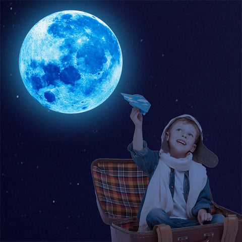 Child in aviator cap below glowing blue moon from 1088 Piece Glow In The Dark Stars And Moon Wall Decals Kit For Kids Room Ceiling Night Sky Decor