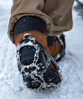 Close-up of boot with Grippy Ice Cleats For Boots And Shoes With Stainless Steel Micro Spikes, showing traction on snow