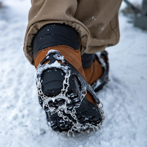 Close-up of boot with Grippy Ice Cleats For Boots And Shoes With Stainless Steel Micro Spikes, showing traction on snow